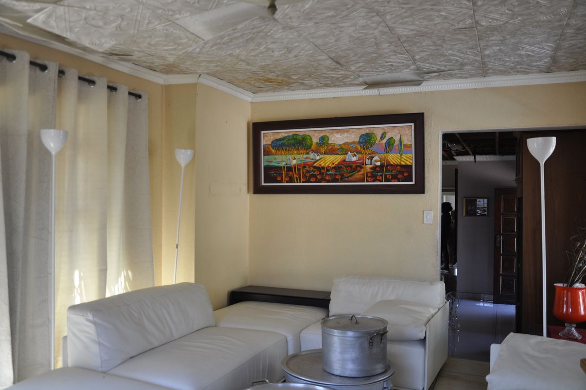 A living room featuring a textured ceiling and access to an adjacent hallway, providing a functional space with potential for cosmetic updates.