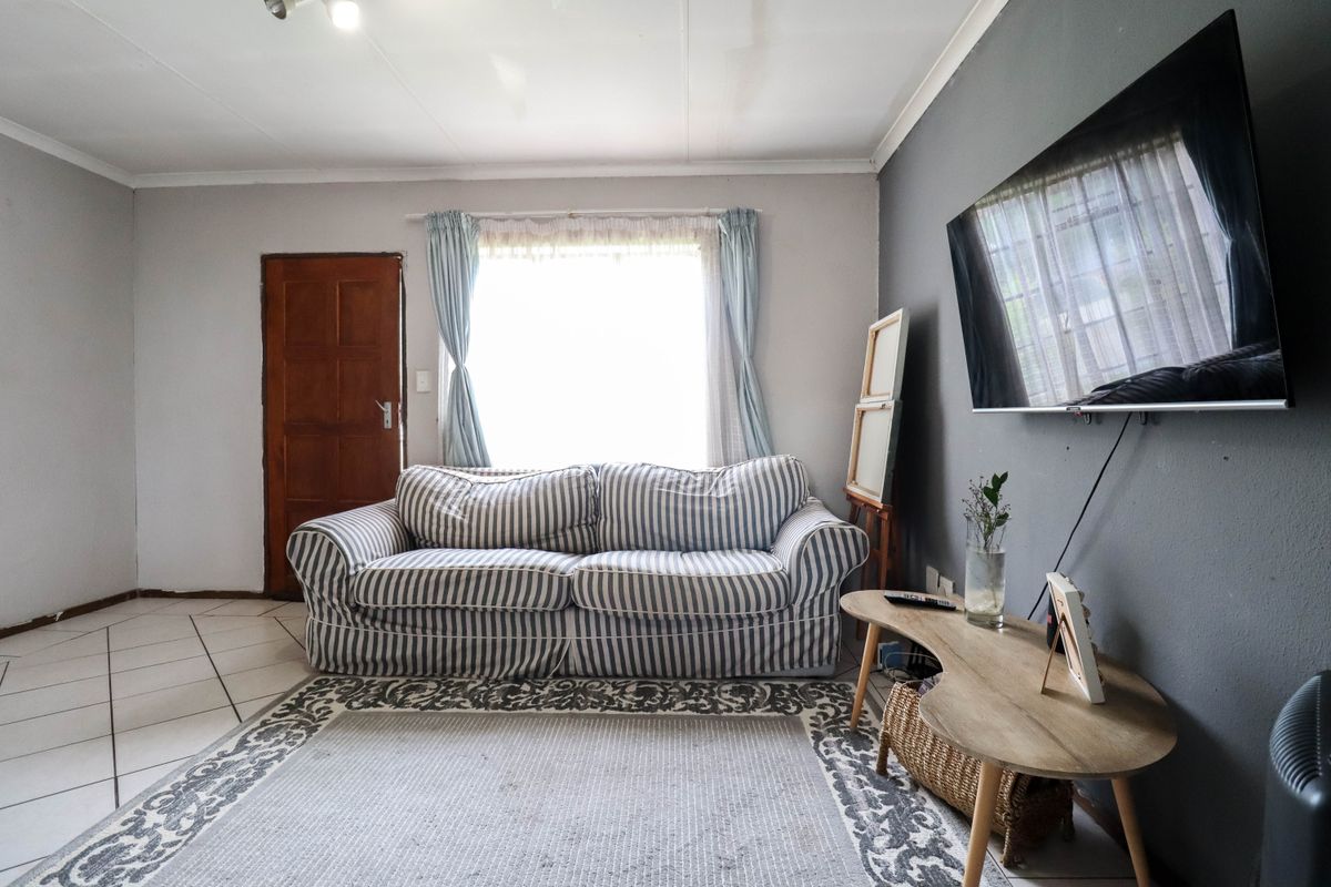 A living room featuring tiled flooring and a neutral color palette, providing a functional space with potential for modern updates.