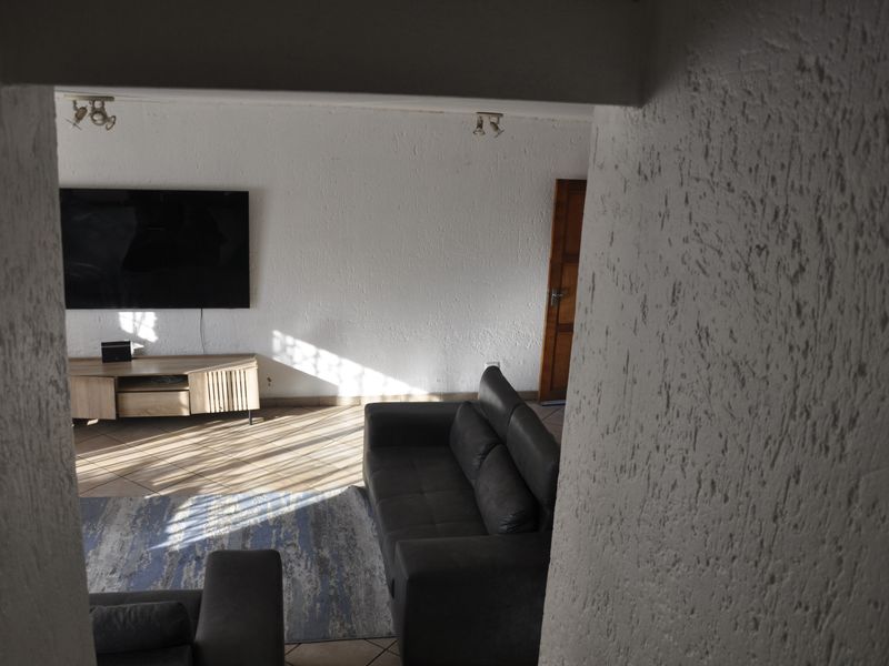 A view into a living room featuring tiled flooring and textured walls, captured from an adjacent space.
