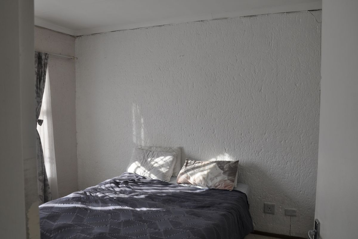 A bedroom featuring textured walls and standard electrical outlets, requiring cosmetic updates to improve the overall finish and aesthetic appeal.