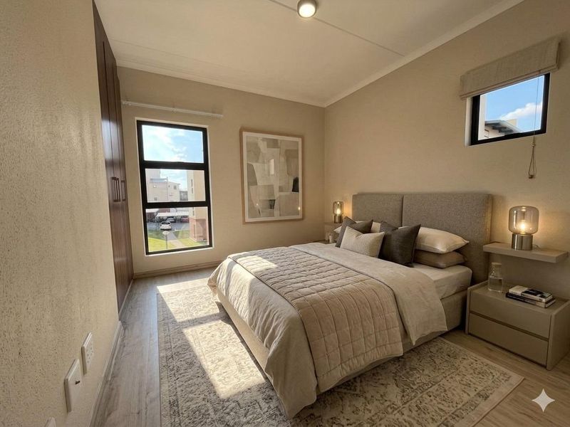 A well-lit, modern bedroom featuring laminate flooring, built-in cupboards, and aluminium window frames, offering a clean and contemporary living space.