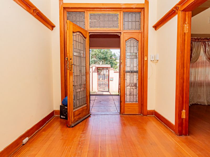 Entrance hall featuring original timber flooring, leaded glass door, and classic timber detailing, providing a warm and character-filled welcome to the home.