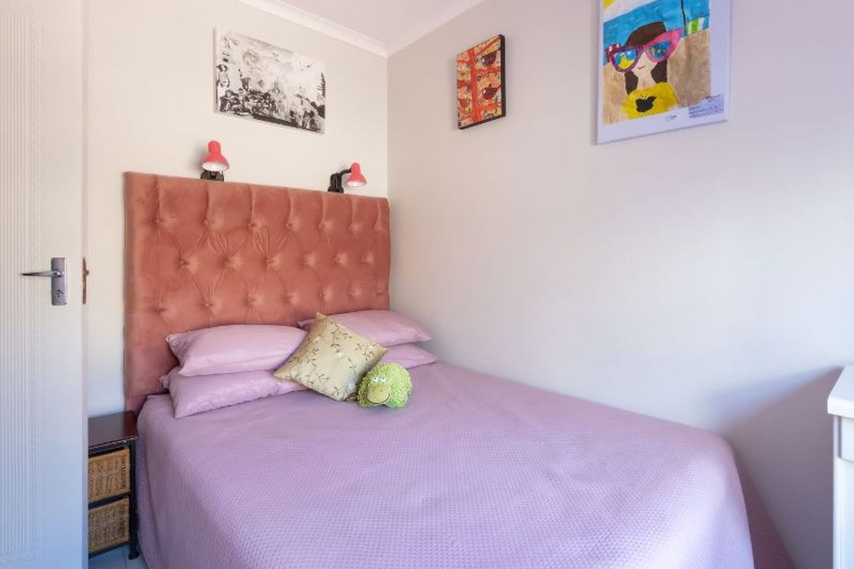 A compact bedroom featuring neutral wall finishes, cove cornicing, and a standard internal door.