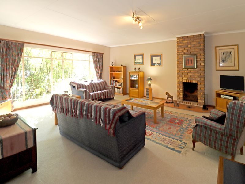 Spacious living room featuring a classic brick fireplace and a large sliding glass door that provides ample natural light.