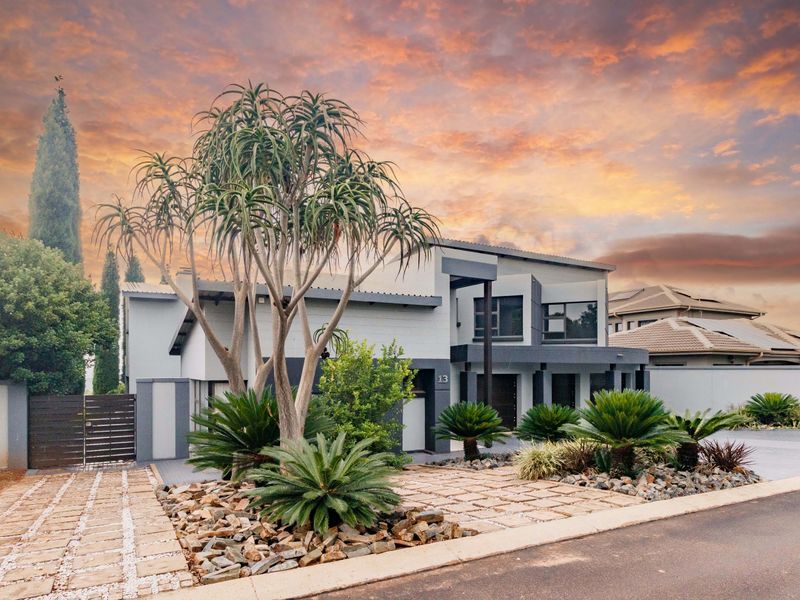 Modern double-story residential property featuring a contemporary facade, paved driveway, and well-maintained landscaped front garden.