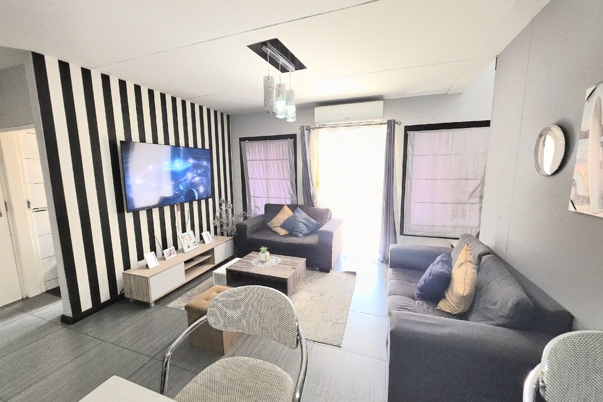 A living room featuring tiled flooring, a split-system air conditioner, and recessed ceiling lighting, providing a functional and comfortable space.