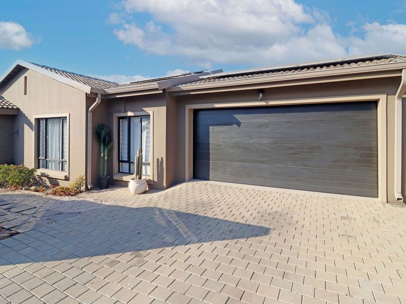 Modern front facade featuring a paved driveway, double garage, and well-maintained exterior finishes with neutral wall tones.