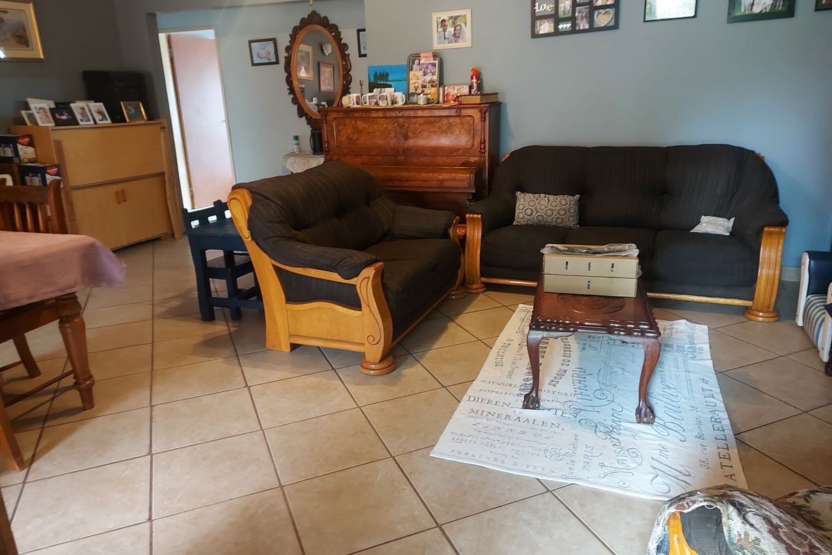 A living room area featuring ceramic floor tiles and neutral wall finishes, providing a functional space for relaxation.