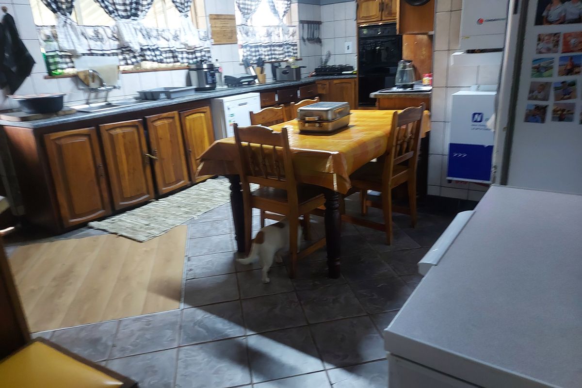 A functional kitchen featuring wooden cabinetry, tiled flooring, and a built-in oven, offering a traditional layout with ample storage and workspace.