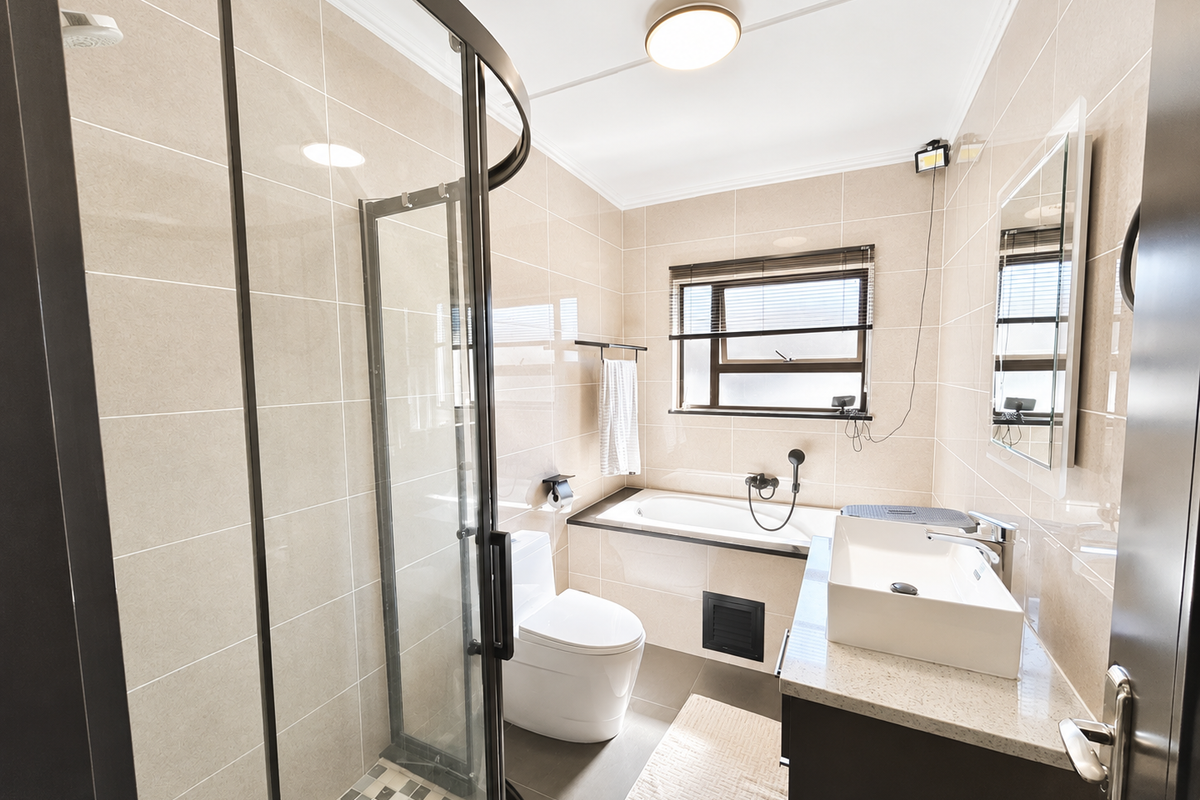 Modern bathroom featuring a glass shower enclosure, built-in bathtub, contemporary vanity basin with stone countertop, and neutral floor-to-ceiling wall tiling.