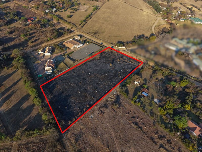 Aerial view of a rectangular vacant residential plot with clear boundary markings, situated in a semi-rural residential area.