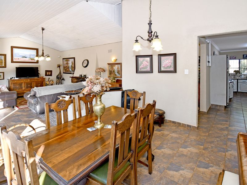 Open plan living and dining area featuring vaulted ceilings, tiled flooring, and a direct view into the adjacent kitchen space.