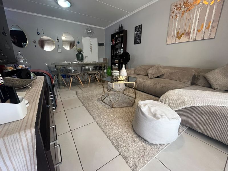 Open-plan living and dining area featuring neutral tiled flooring and a coved ceiling, providing a functional and versatile space for daily living.