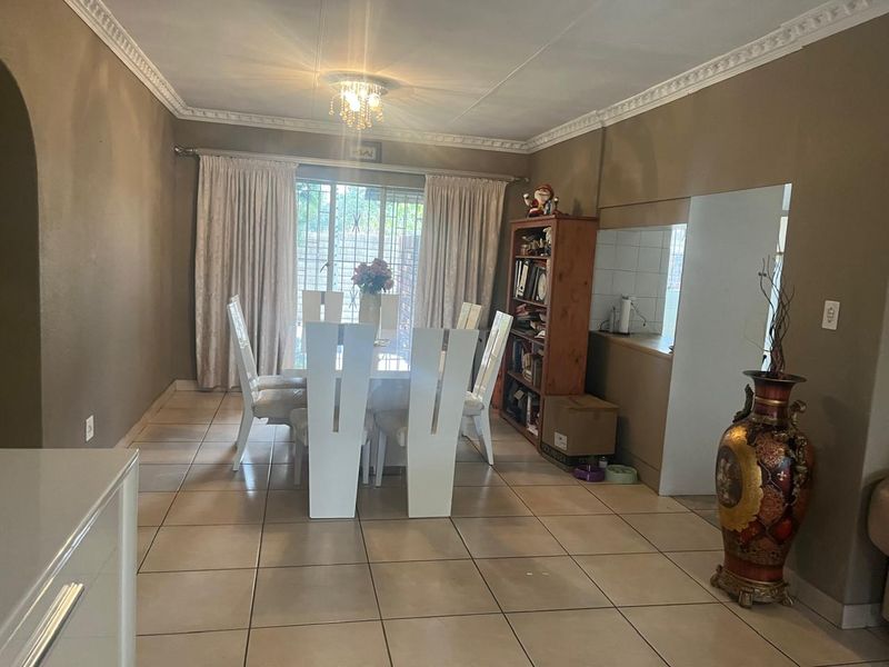 Dining area featuring tiled flooring, decorative ceiling cornices, and a sliding glass door providing access to the exterior.