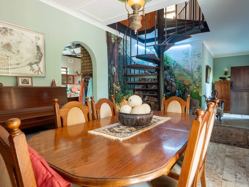 Dining area featuring a distinctive spiral staircase, arched entryway, and tiled flooring, creating a unique architectural focal point within the home.