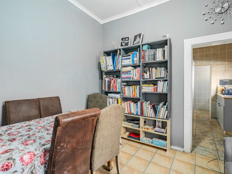 A dining area featuring tiled flooring and neutral wall finishes, with direct access to the adjacent kitchen space.
