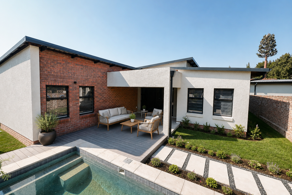 Rear exterior view of a modern townhouse featuring a swimming pool, composite deck, covered patio area, and landscaped garden with a paver walkway.