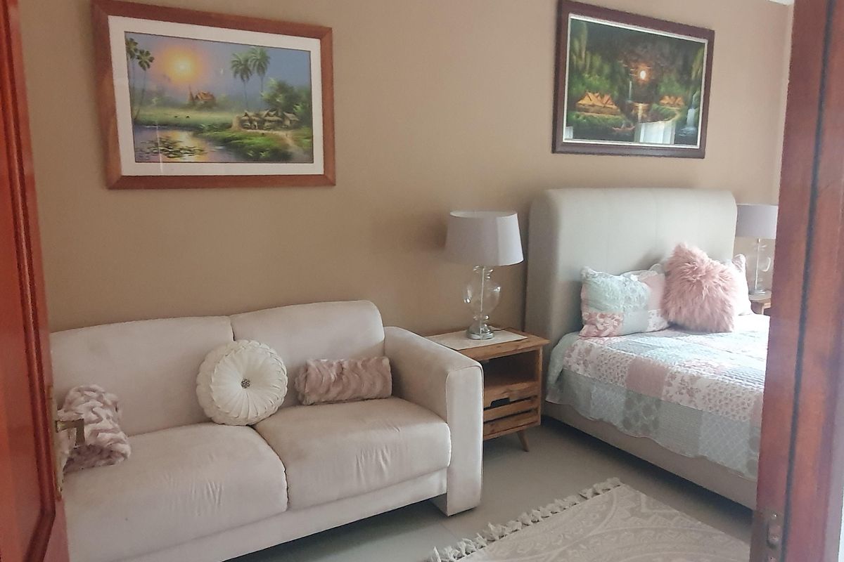 A bedroom featuring neutral wall tones, tiled flooring, and a doorway entrance, providing a comfortable and functional living space.