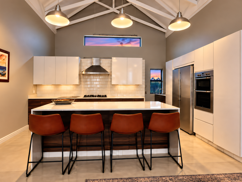Modern kitchen featuring a central island, high-end built-in appliances, subway tile backsplash, and striking exposed roof trusses with contemporary pendant lighting.