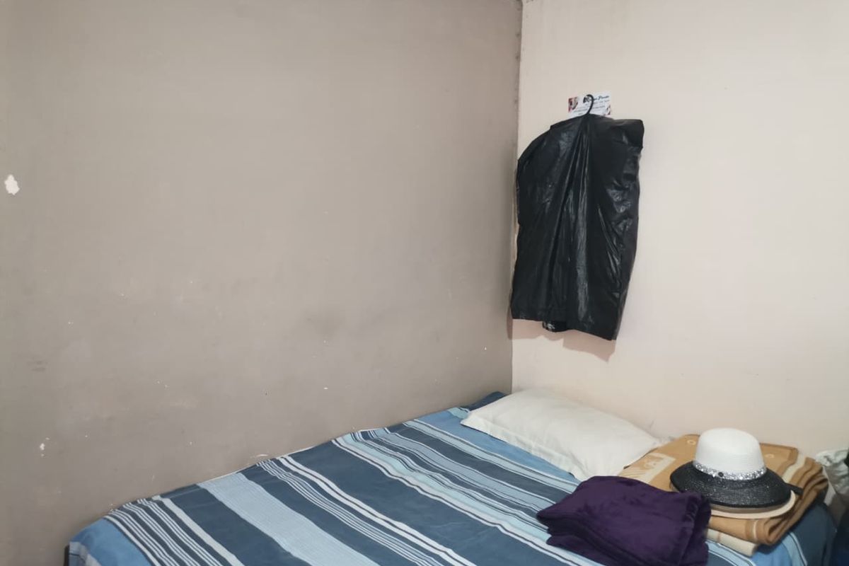 A compact bedroom space featuring neutral painted walls and standard ceiling cornicing.