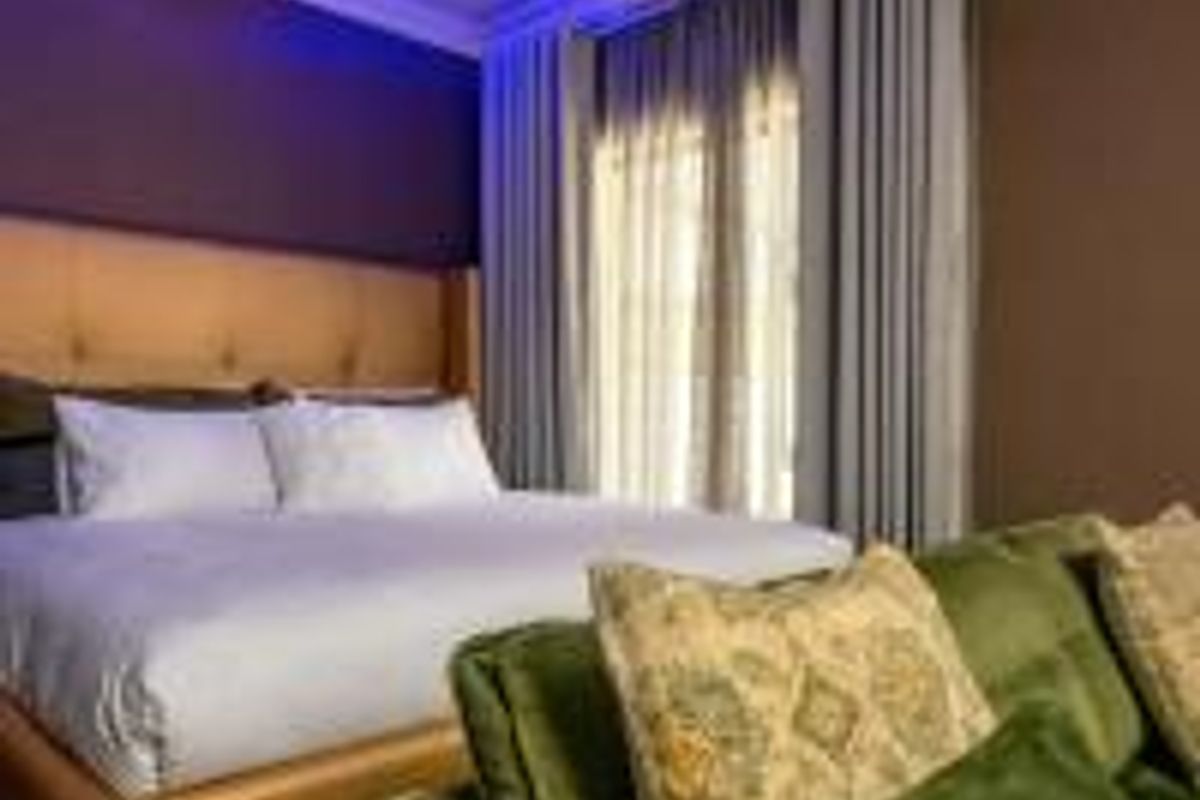 A well-maintained bedroom featuring an air conditioning unit, recessed lighting, and floor-to-ceiling curtains.