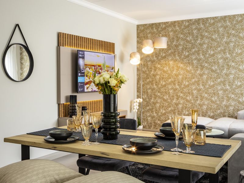 A well-presented living area featuring a decorative feature wall, modern coving, and integrated wall paneling for a television.