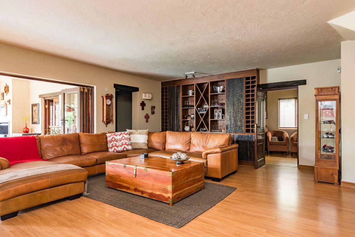 Spacious living room featuring laminate flooring and a large built-in wooden shelving unit with integrated storage.