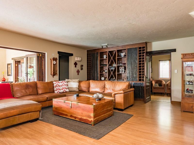 Spacious living room featuring laminate flooring and a large built-in wooden shelving unit with integrated storage.