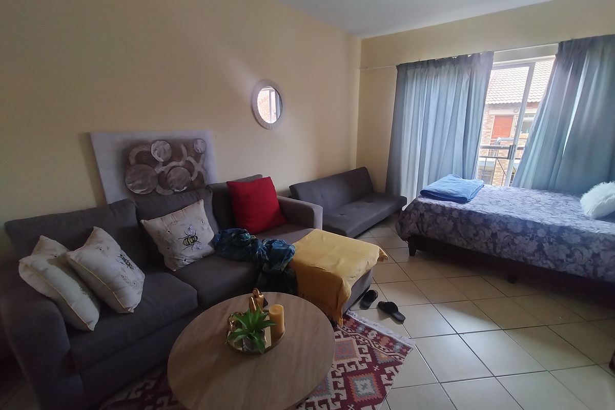 A living room area featuring tiled flooring and a sliding glass door providing access to an outdoor space.