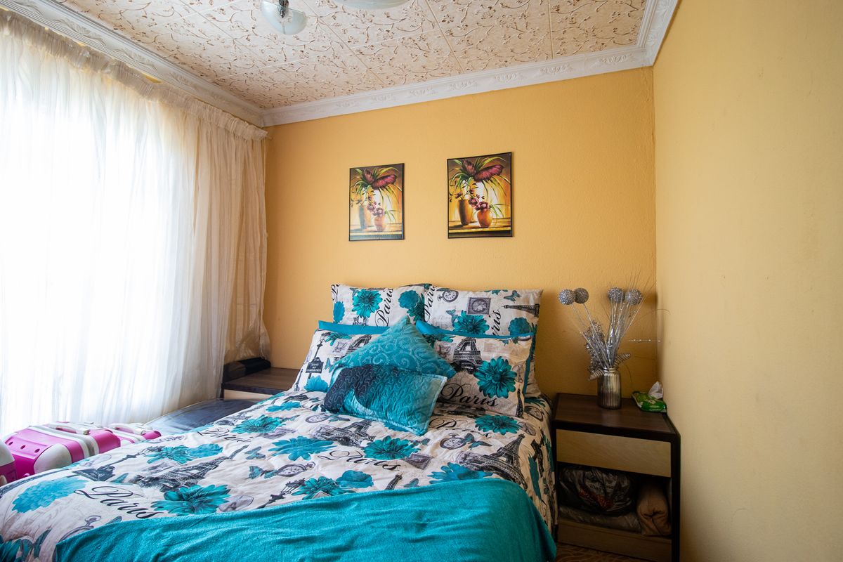 A bedroom featuring decorative ceiling tiles and crown molding, providing a classic architectural detail to the space.