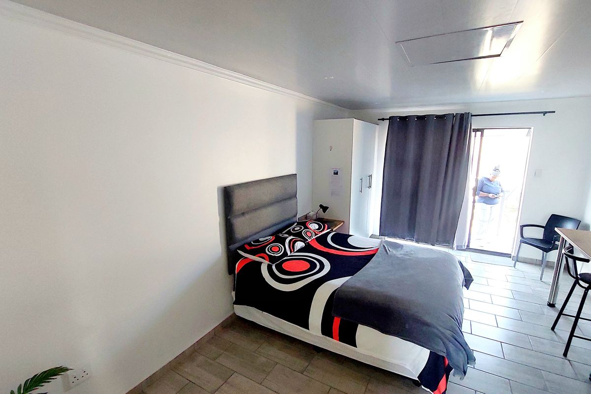 A bedroom featuring tiled flooring, a built-in wardrobe, and a sliding glass door providing access to an outdoor area.
