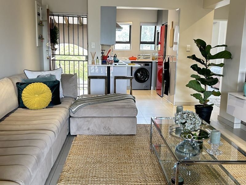 Open-plan living area featuring a modern kitchen with island, tiled flooring, recessed lighting, and direct access to a secure entrance.