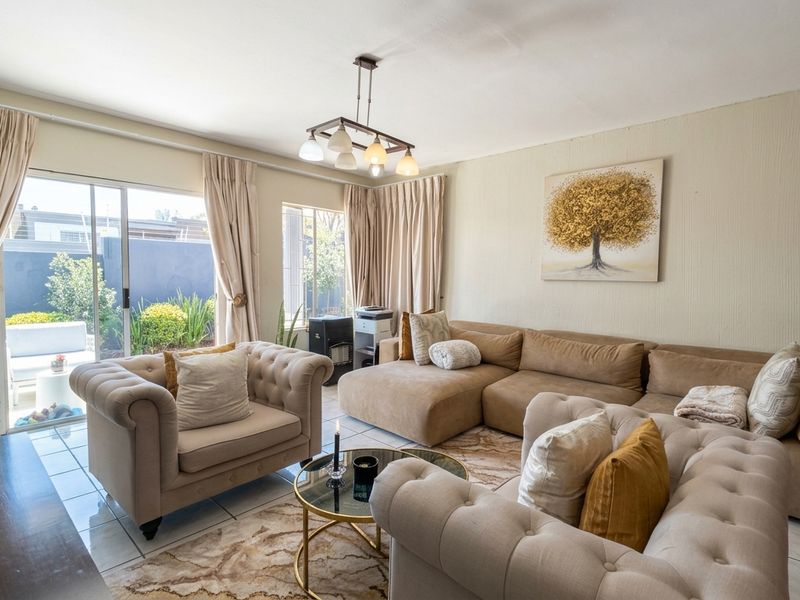 A bright living room featuring tiled floors and large sliding glass doors that provide direct access to the outdoor patio area.