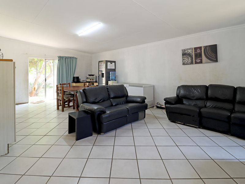 Spacious open-plan living and dining area featuring ceramic floor tiles and a sliding glass door providing access to the exterior.