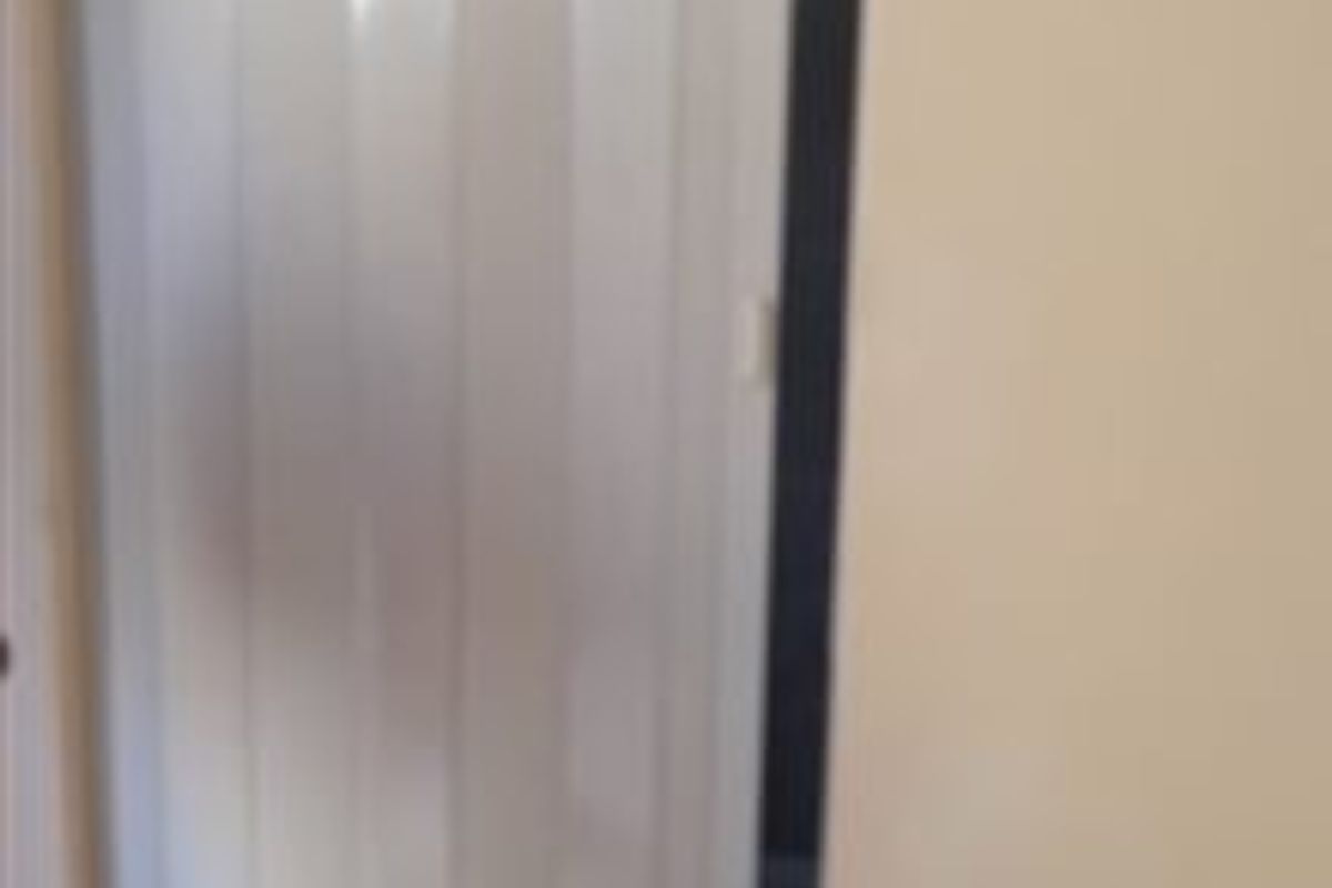 A view of a white folding door within an interior hallway space.