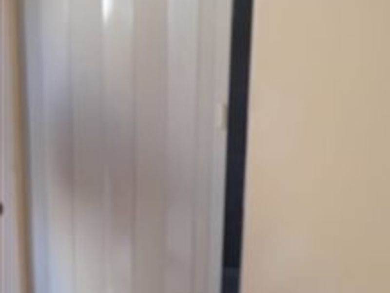 A view of a white folding door within an interior hallway space.