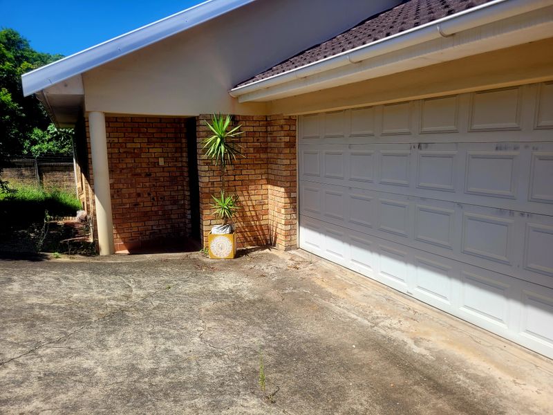 Front exterior view of the townhouse featuring a brick facade, a white sectional garage door, and a concrete driveway.