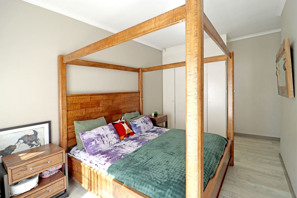 A well-maintained bedroom featuring built-in cupboards and neutral tiled flooring, providing a clean and functional living space.