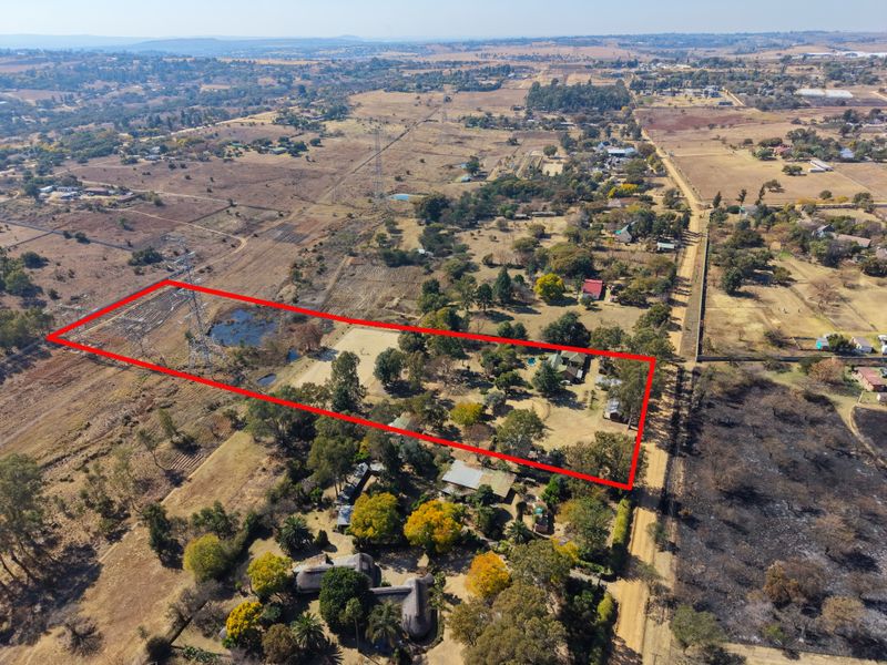 Aerial view of a large, expansive residential plot featuring mature trees, established landscaping, and clear boundary markings within a rural setting.