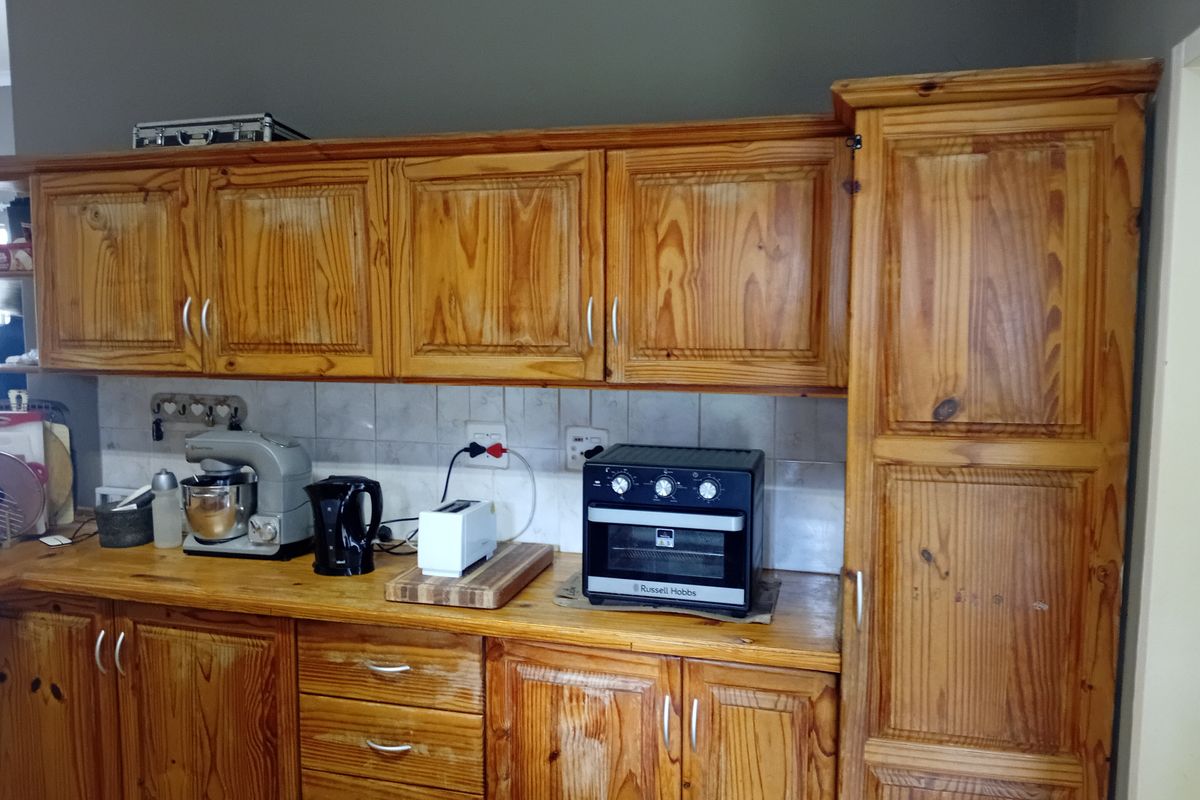 A kitchen featuring traditional wooden cabinetry, a tiled backsplash, and wooden countertops, offering a classic aesthetic with potential for modern updates.