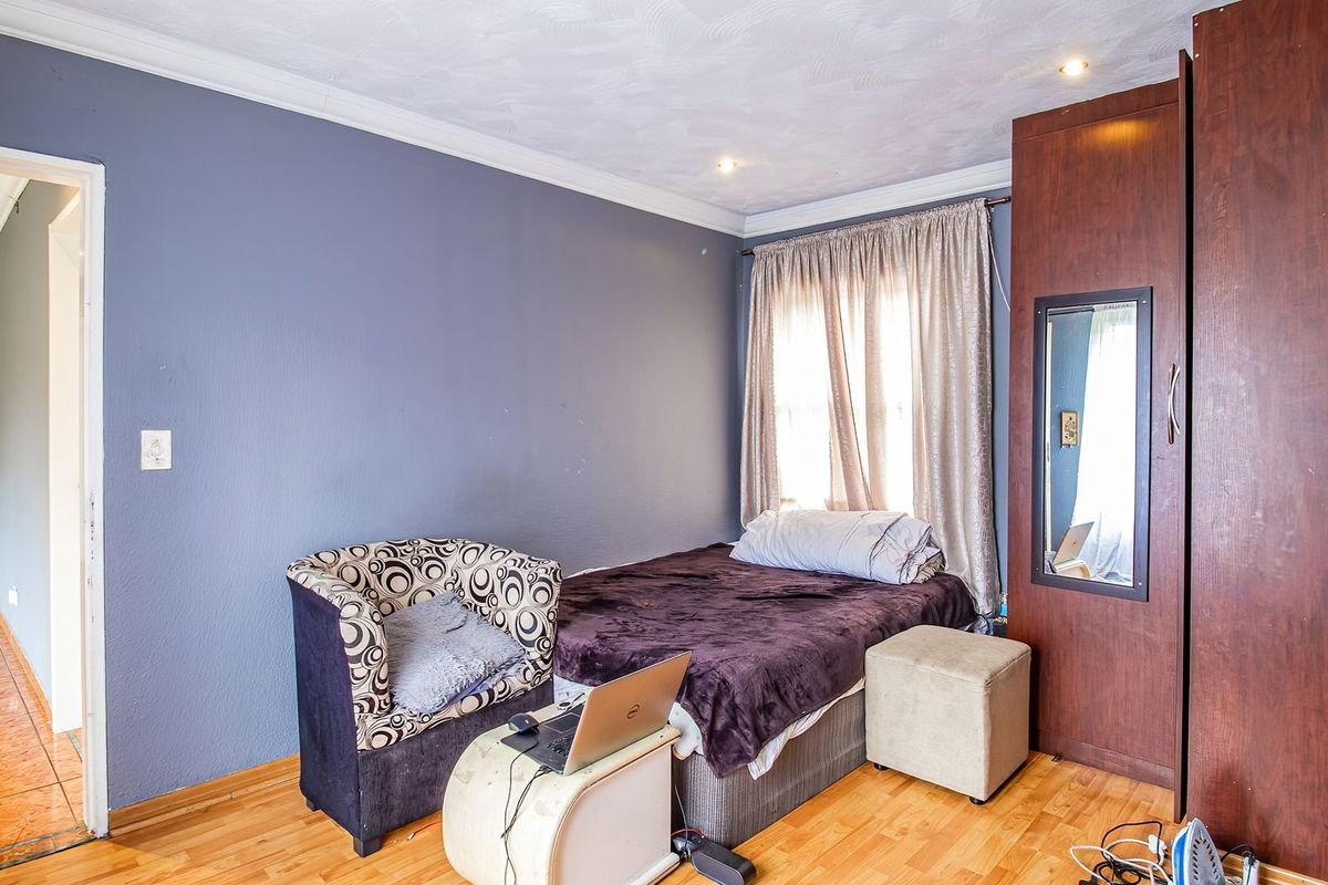 A bedroom featuring laminate flooring, recessed ceiling lighting, and a built-in wooden wardrobe.