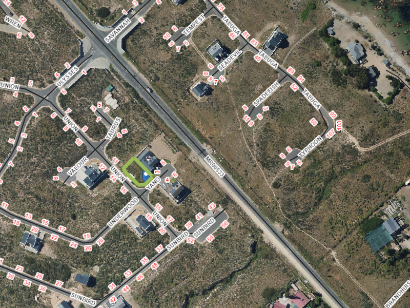 An aerial view of a residential property highlighting the plot boundaries, swimming pool, and surrounding coastal estate infrastructure.