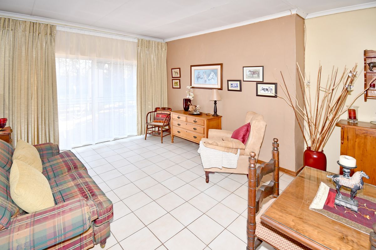 A living room featuring tiled flooring and a large sliding glass door providing access to the exterior.