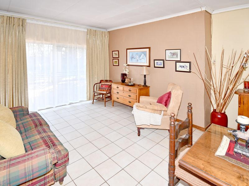 A living room featuring tiled flooring and a large sliding glass door providing access to the exterior.