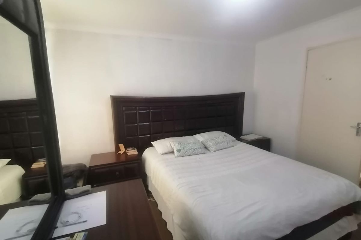 A standard bedroom featuring white walls and a single door, providing a neutral space ready for personalization.