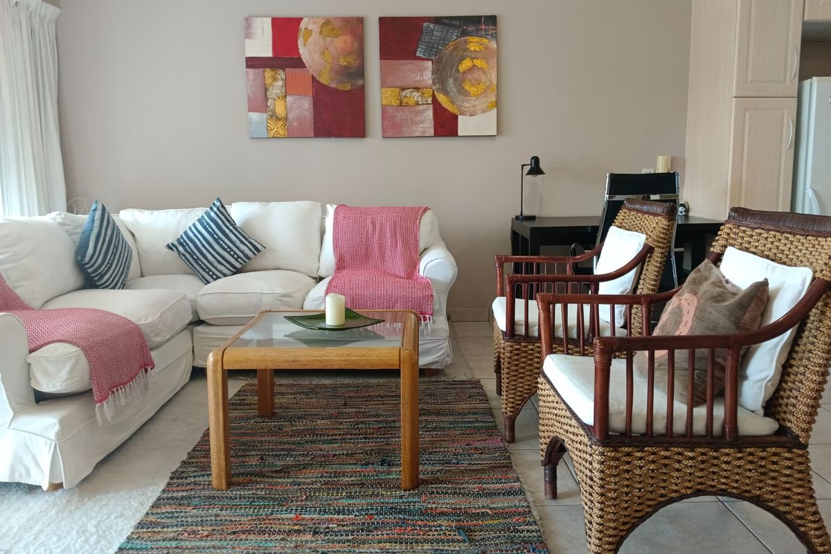 A comfortable living room area featuring neutral wall tones and tiled flooring, providing a functional space for relaxation and seating.
