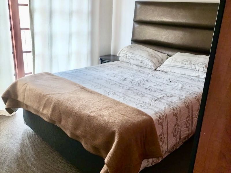 A bedroom featuring carpeted flooring and a glass-paneled french door providing natural light.