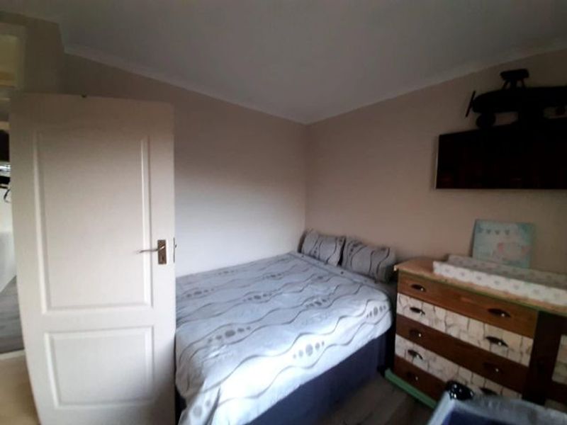 A standard bedroom featuring neutral wall tones and a functional layout, suitable for a comfortable sleeping space.