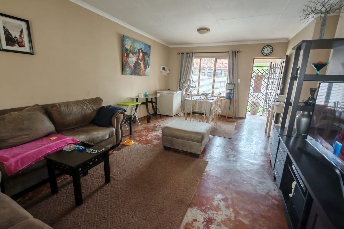 Spacious living area featuring tiled flooring and direct access to the exterior through a security gate.