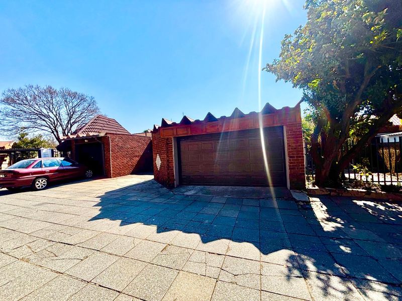 Front exterior view of the townhouse featuring a brick facade, double garage, and a paved driveway area.